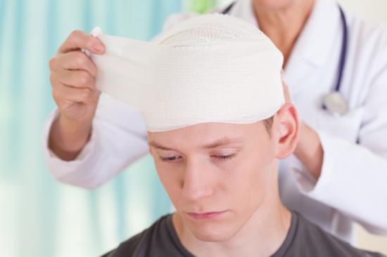 Doctor bandaging injured mans head