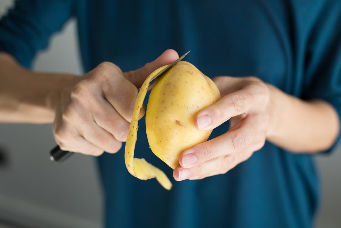man peeling a potato