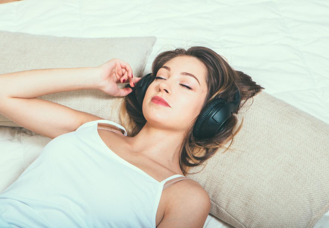 young woman listening to music through headphones