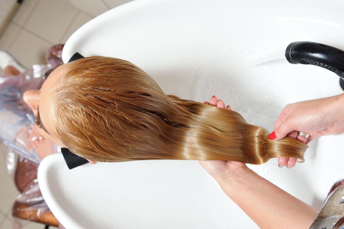 Woman's shiney hair being rinsed in a hair salon