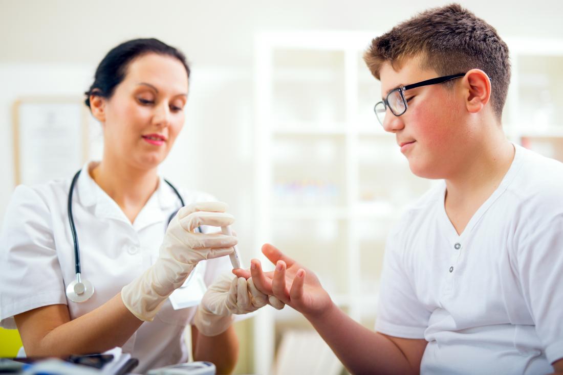 teenage boy being tested for diabetes by doctor