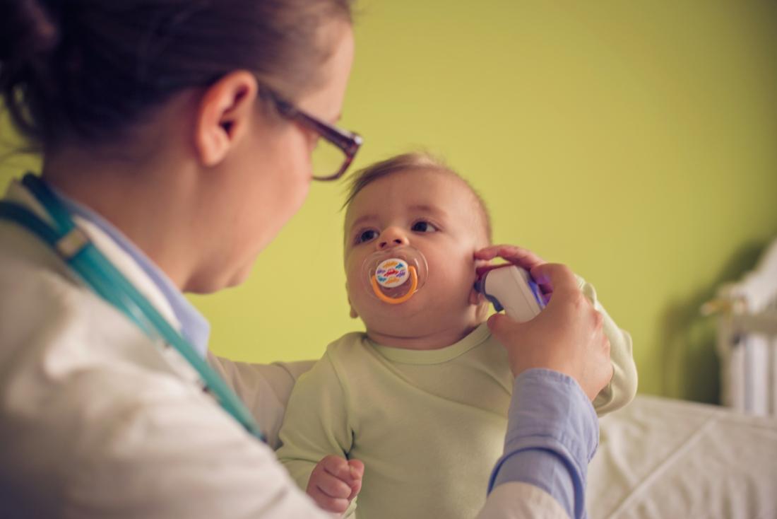 Doctor measuring babies temperature with ear thermometer