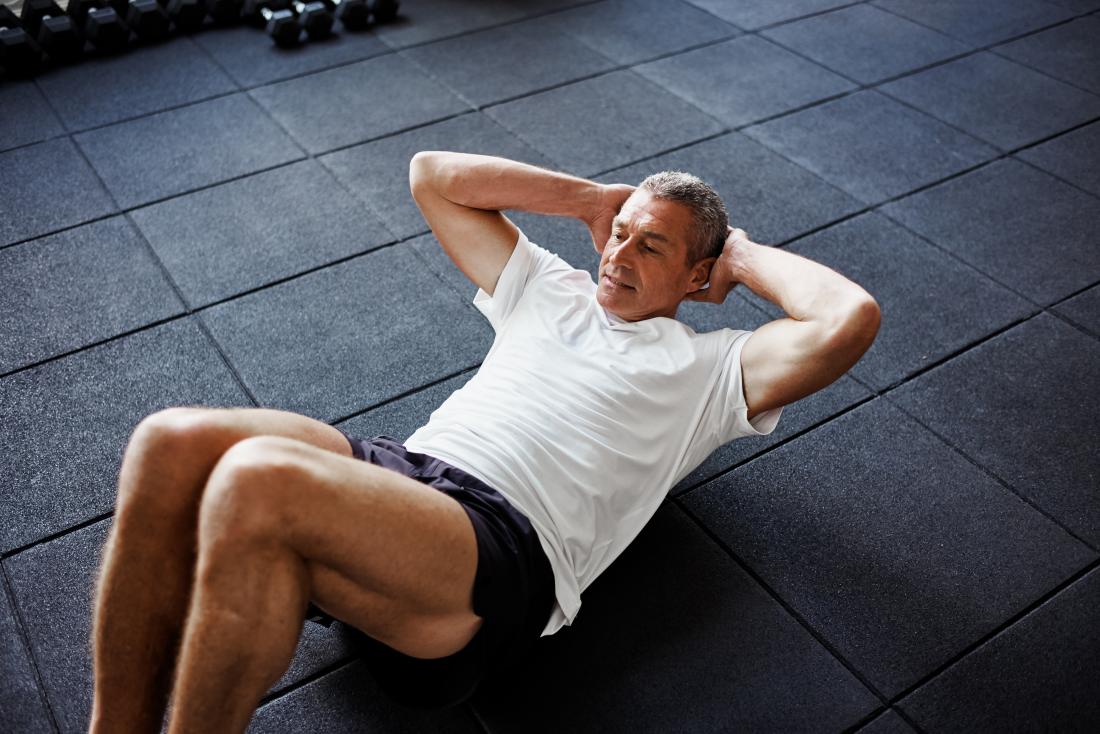 Man doing partial curls or sit ups on floor.