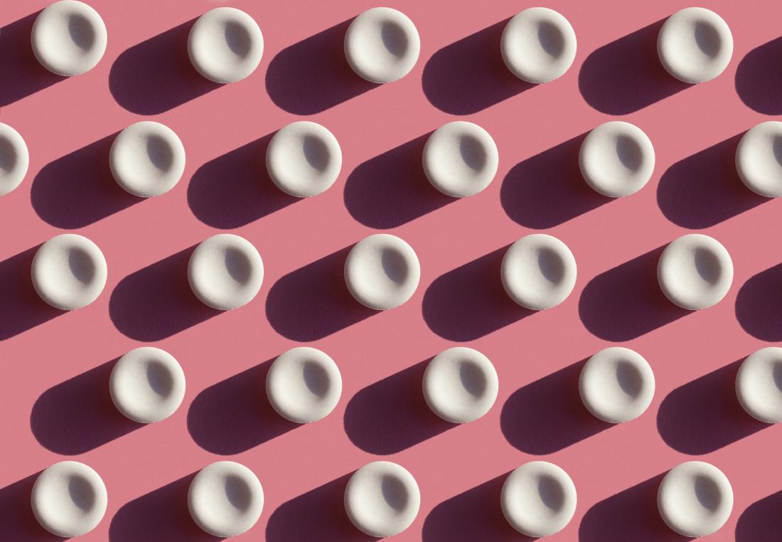 white pills on pink background