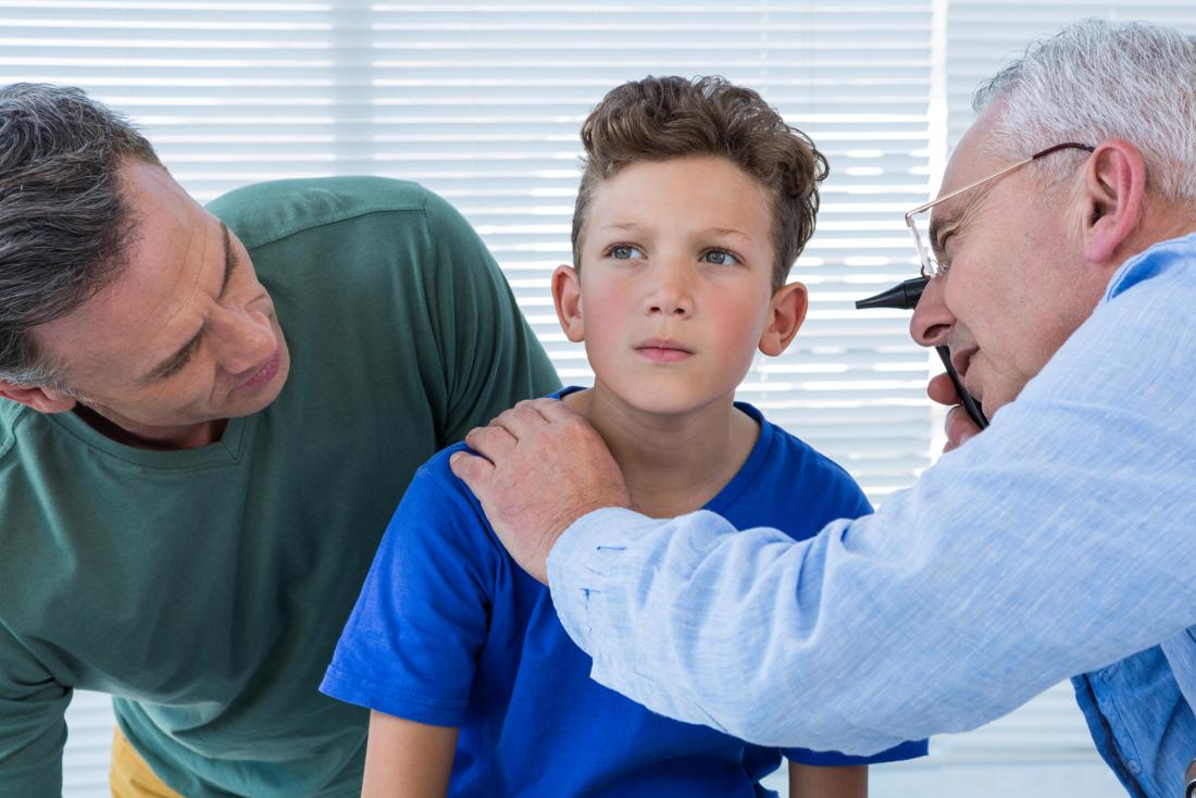 Child having his ear inspected by a doctor