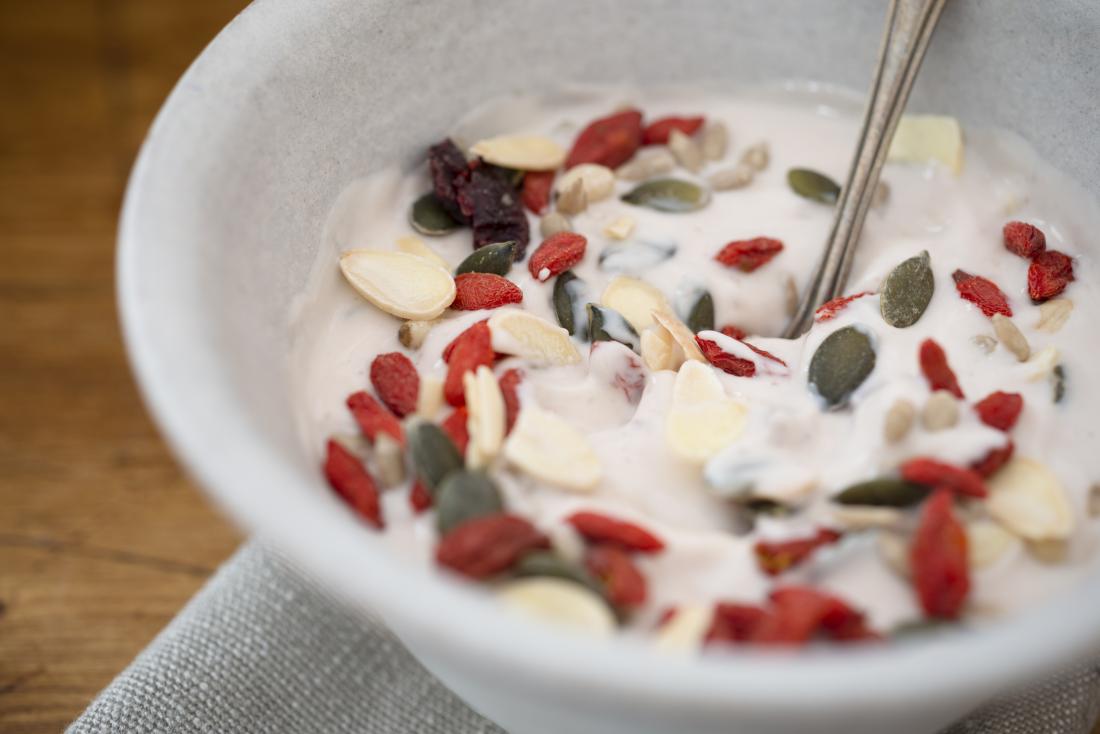 Goji berries and pumpkin seeds in bowl of yoghurt