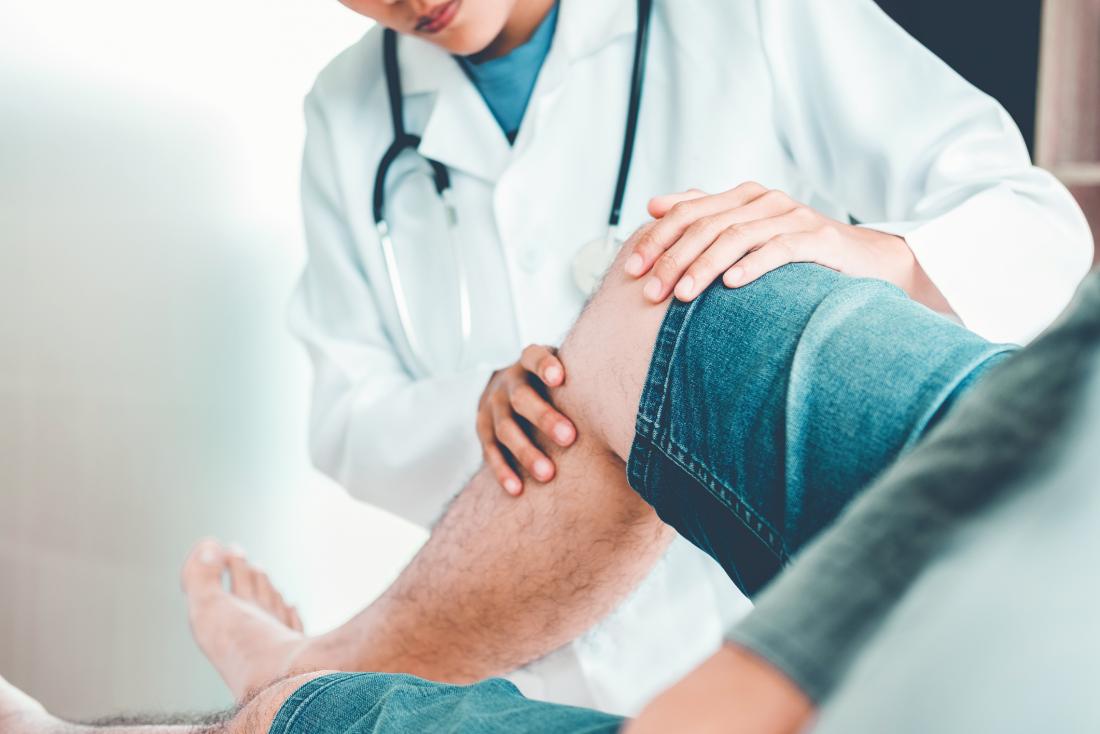 Doctor examining knee with lateral collateral ligament sprain
