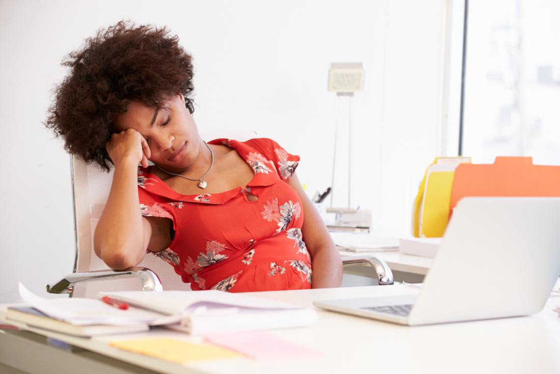 tired woman at office desk
