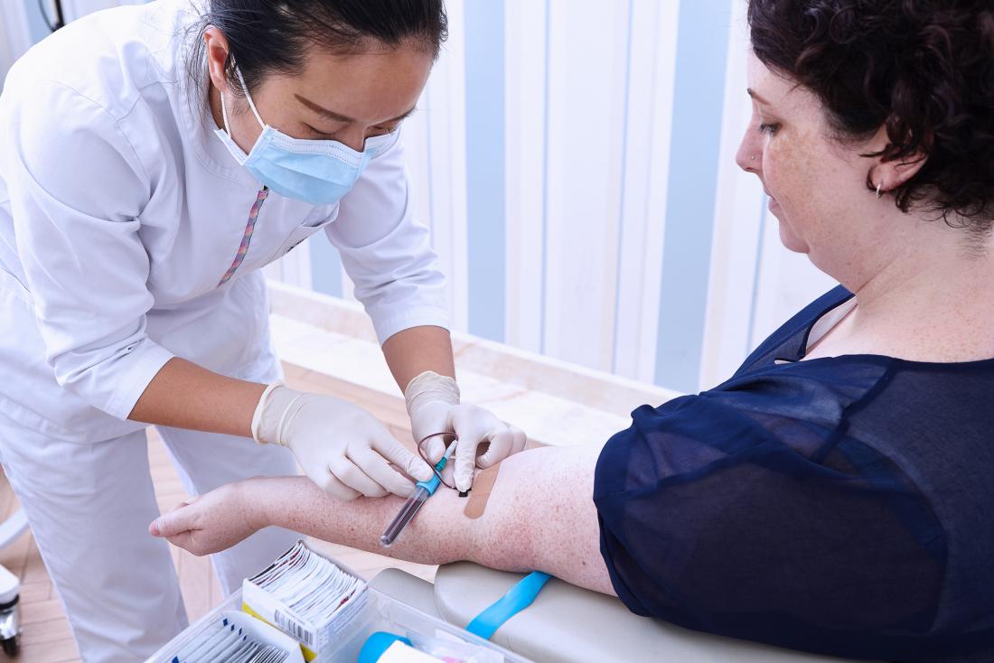 Woman having blood sample drawn from arm for testing