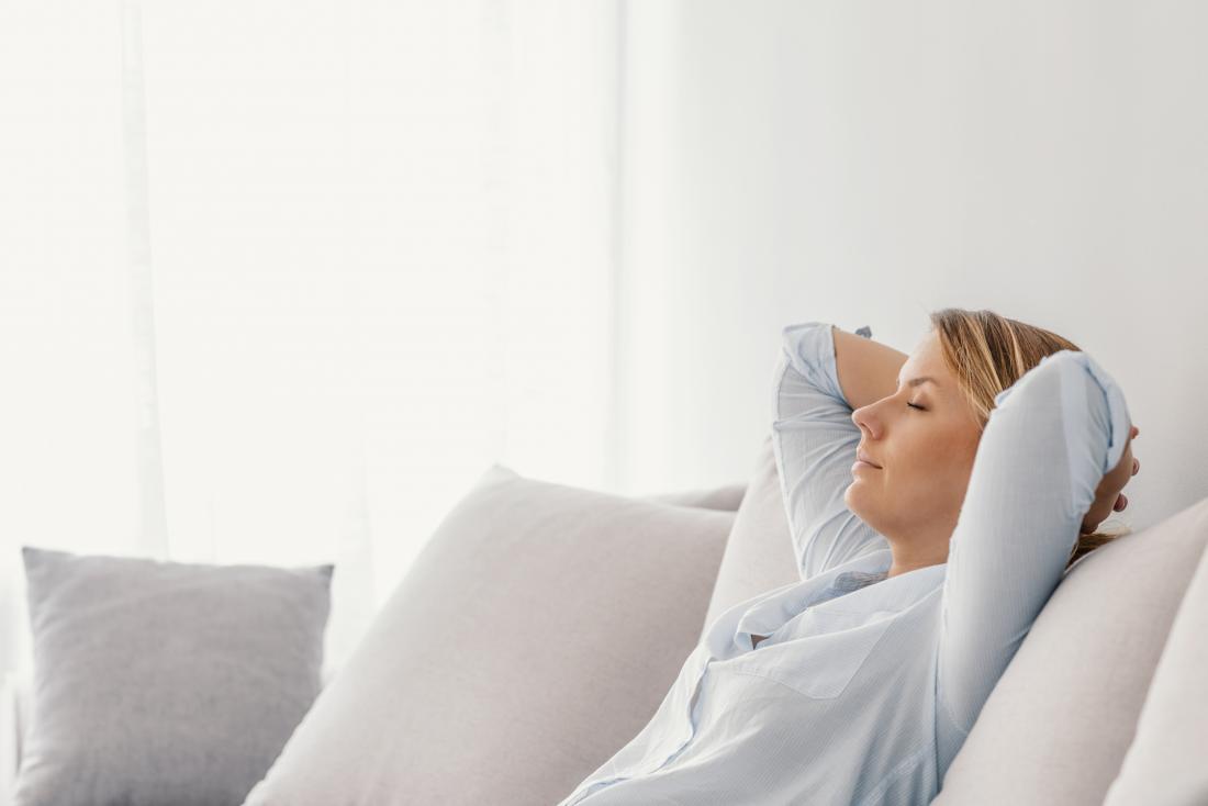 Woman doing breathing exercises on the sofa to improve lung capacity