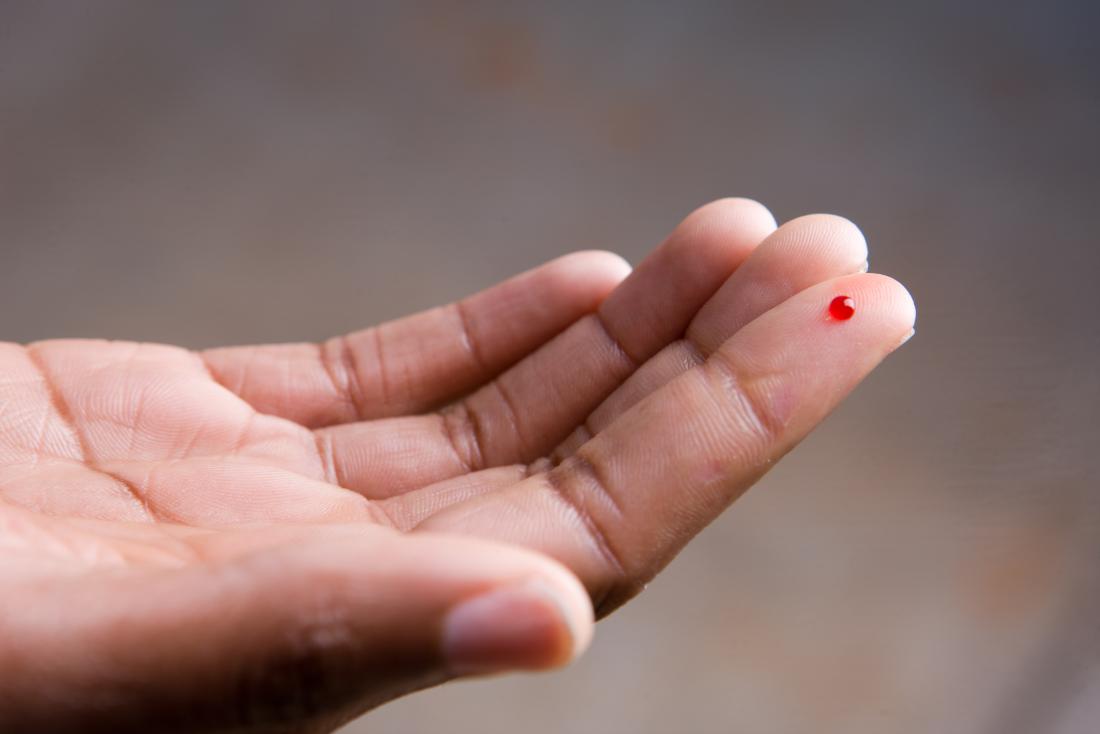 Pinprick blood drop on persons finger