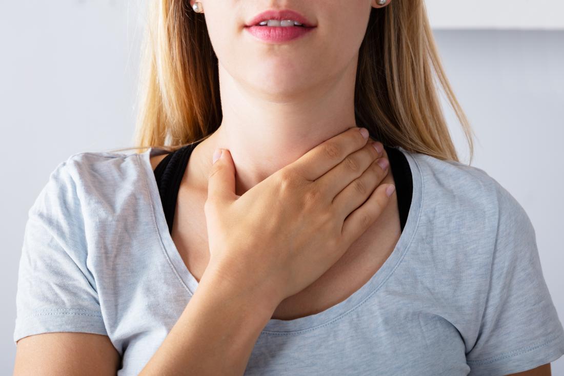 Woman holding her throat due to pain when swallowing caused by esophageal thrush