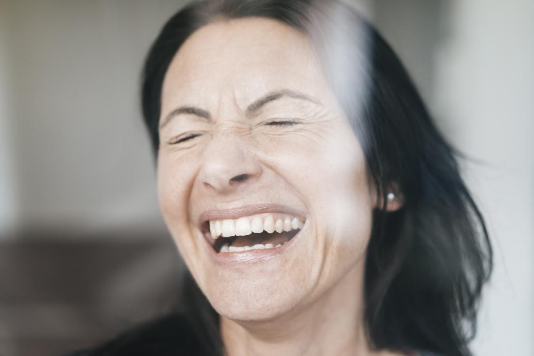 Woman laughing with eyes closed