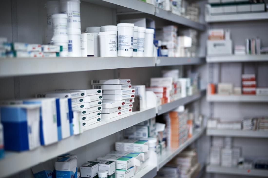 Shelf in pharmacy stocked with prescription medications.