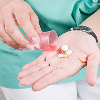 A nurse with prescription drug pills.