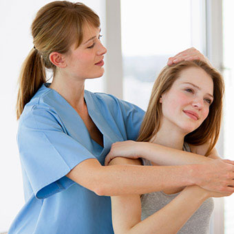 A physical therapist works on the neck and shoulder of a patient with a pinched nerve.