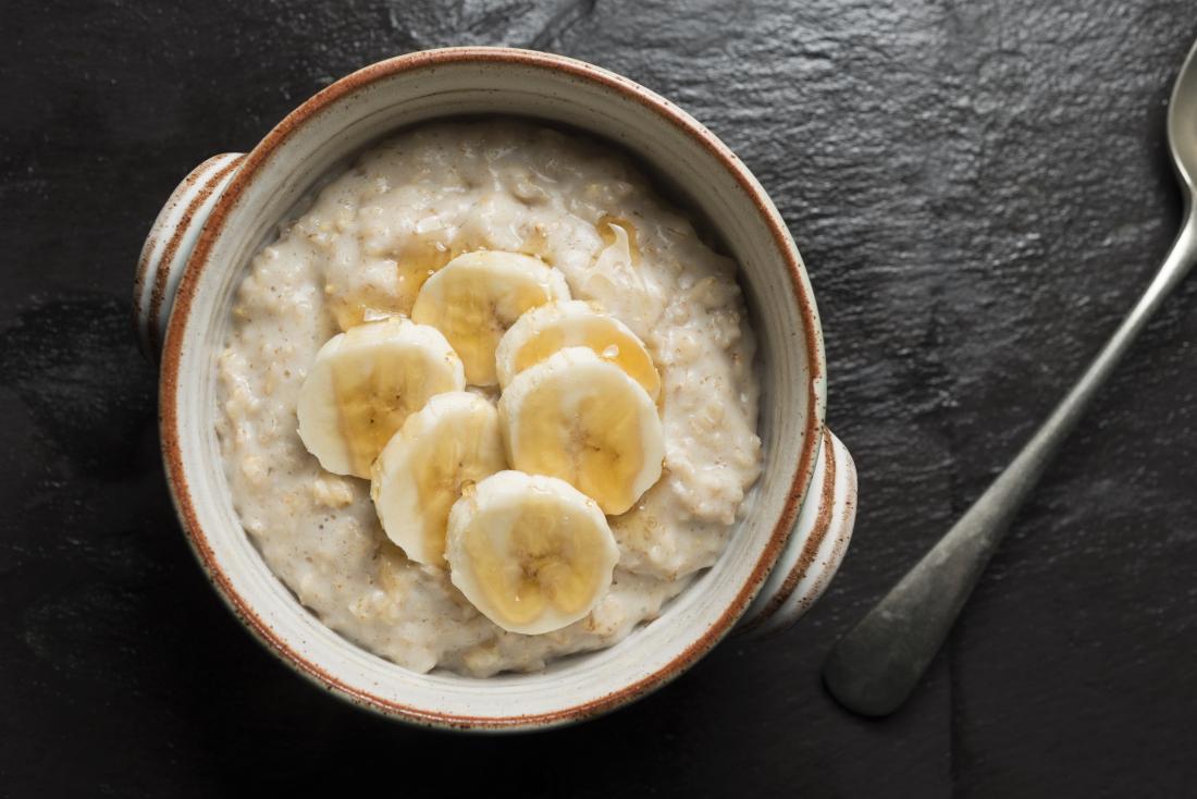 Banana slices and honey drizzled in a bowl of porridge