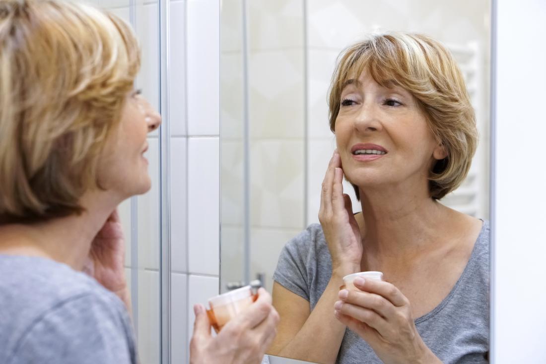 woman using moisturizer on her face to help with menopause rash