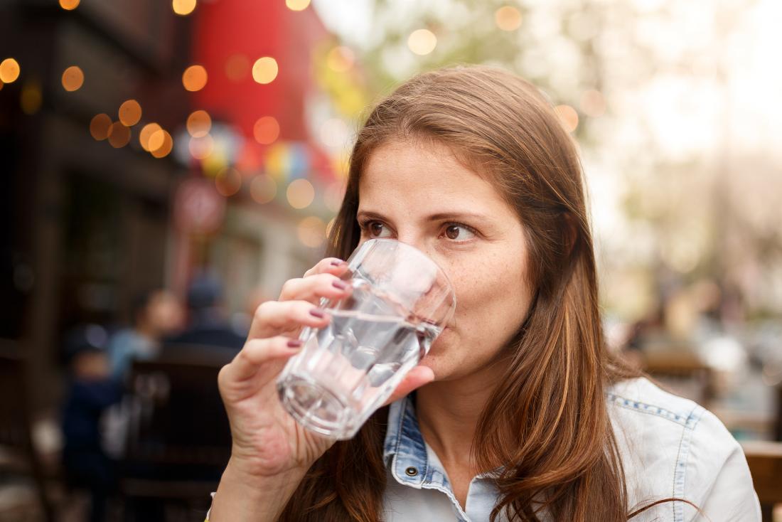 Woman drinking water in the street