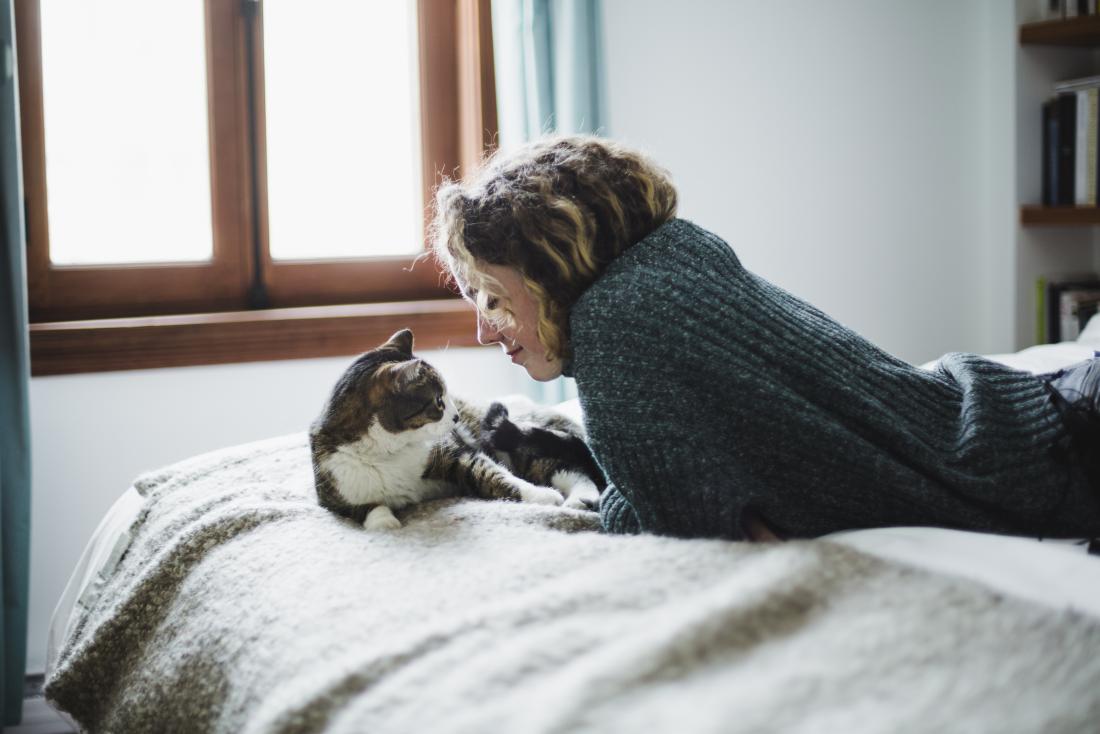Woman playing with her cat to distract from other issues
