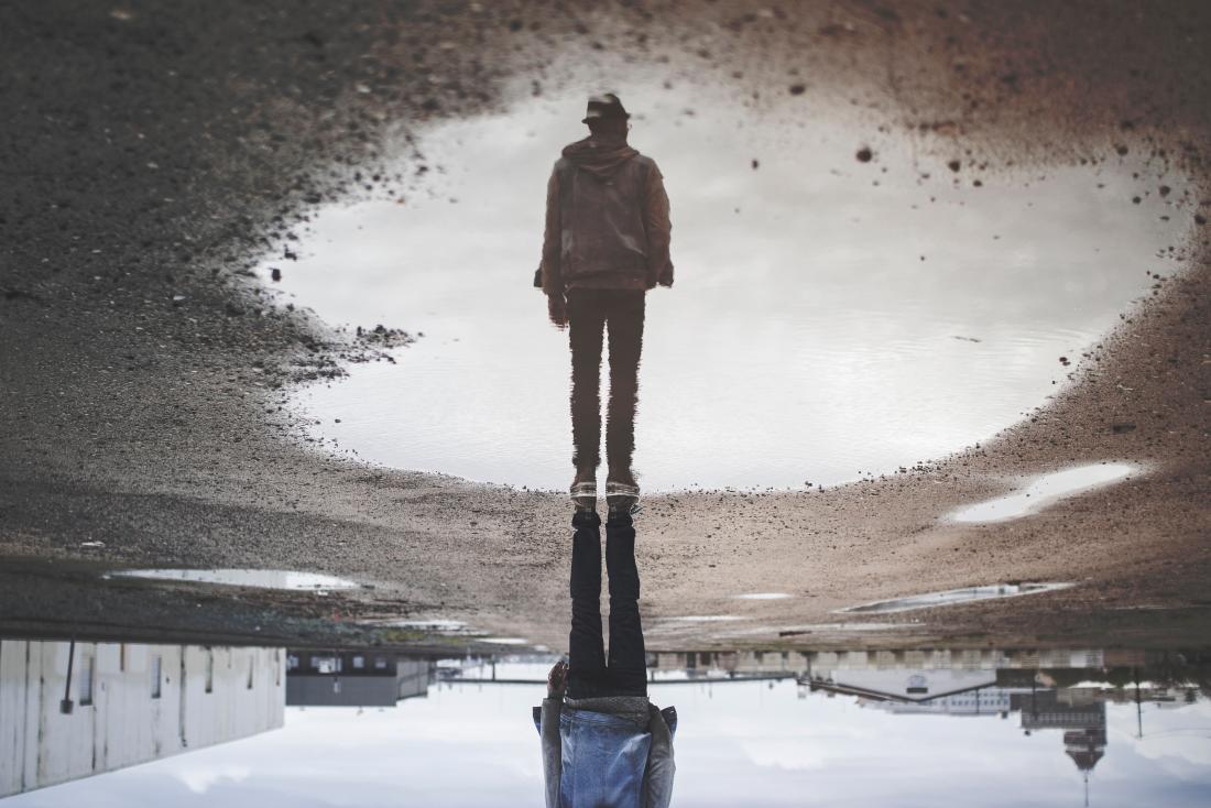 person reflected in a puddle