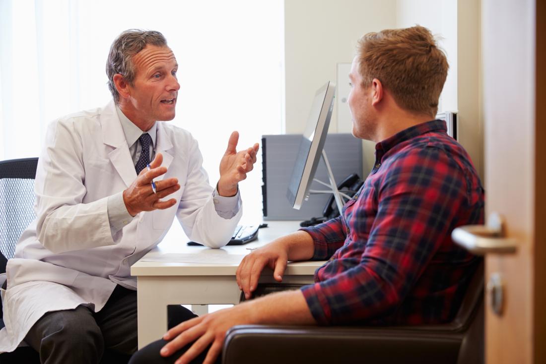 Patient and doctor in office discussing something over desk