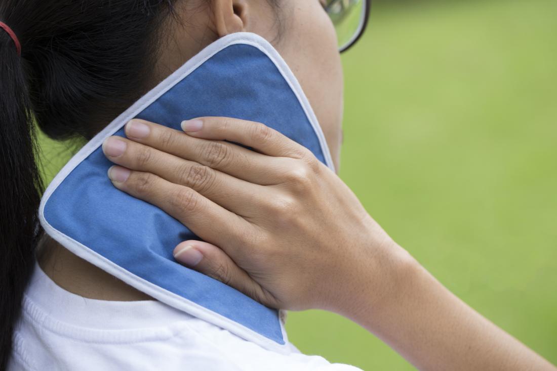 Woman applying cold pack to her neck and shoulder to relieve arthritis pain.