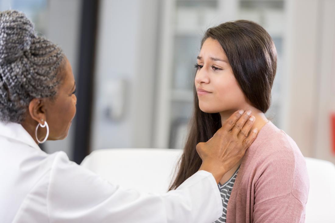 doctor checking person's neck for signs of syphilis