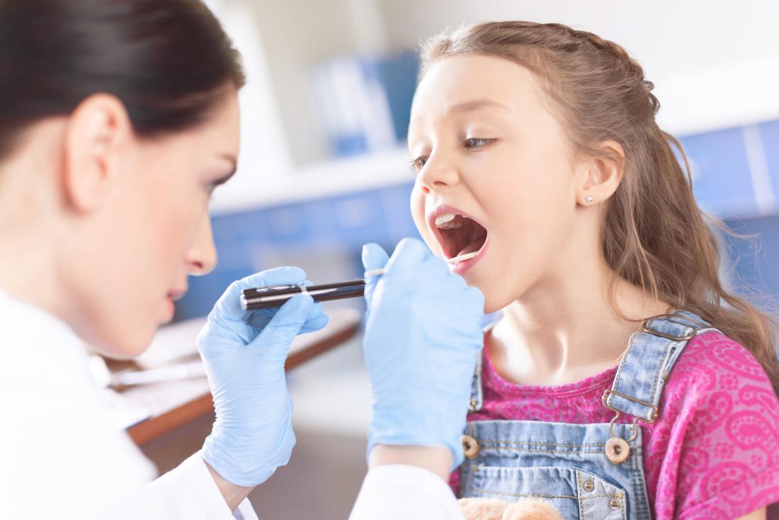 doctor examining young girls throat