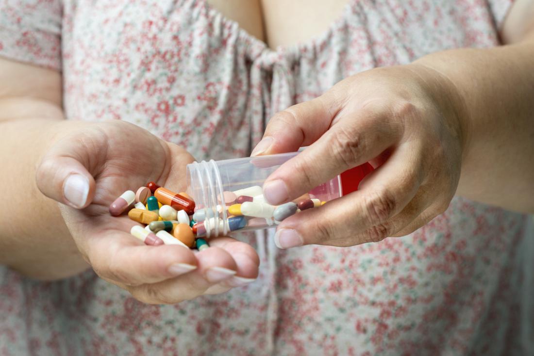 Woman holding a range of pills