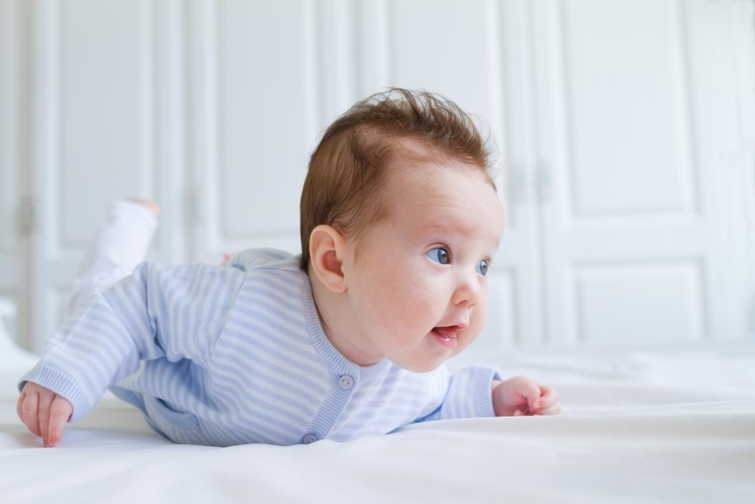 Baby having tummy time crawling on front to treat gas