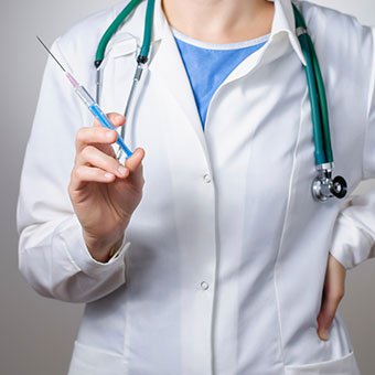 A doctor holds a syringe for a cortisone injection.