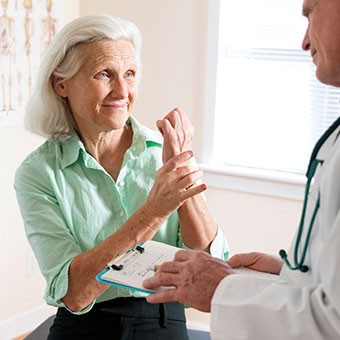 A woman discusses her arthritis wrist pain with her doctor.