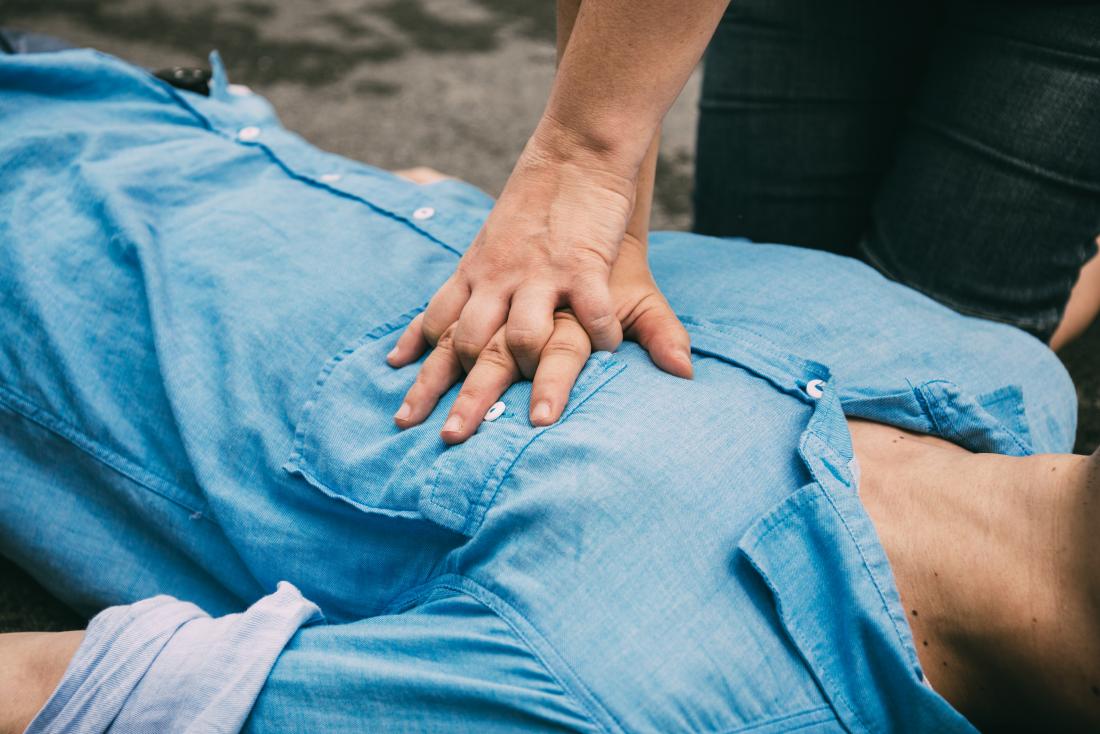 CPR chest compressions being performed on unconscious man