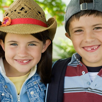 A young girl and boy wear hats.