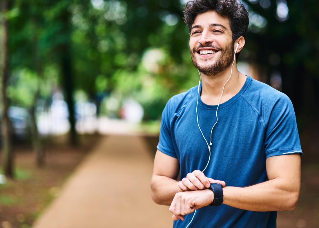 Man outdoors running and jogging smiling and listening to ipod