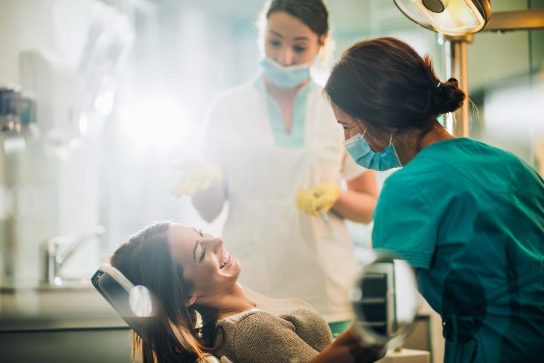 Dentists with smiling patient in chair