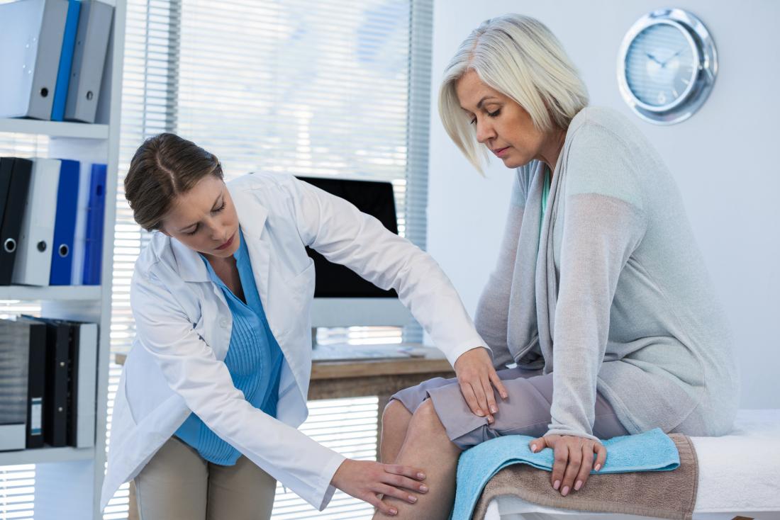 female doctor examining female patients leg