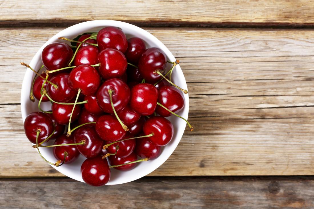 cherries in a bowl on a table