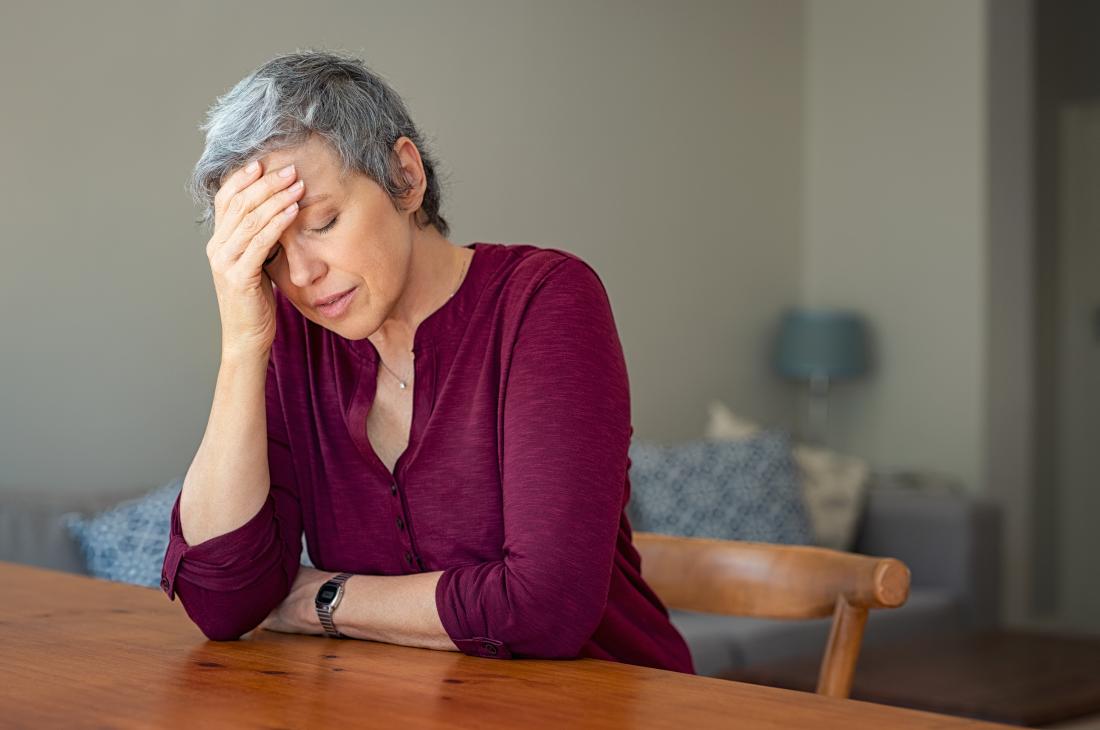 woman with a headache which is a possible side effect of naproxen
