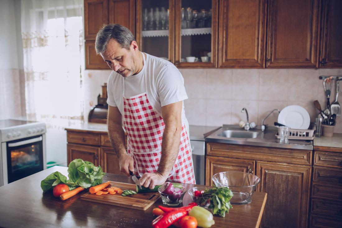 man preparing vegetables in kitchen