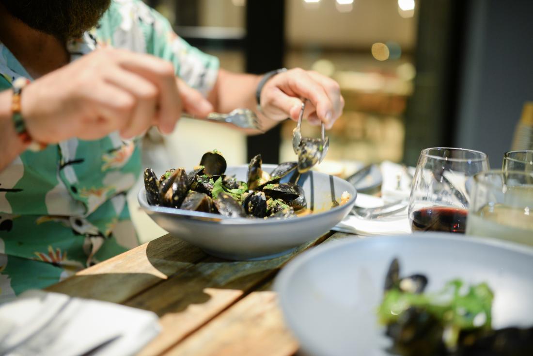 man eating a plate of mussels