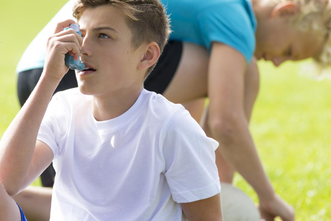 young boy using an inhaler after sport