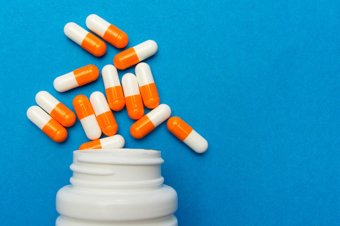 orange and white pills on a blue background