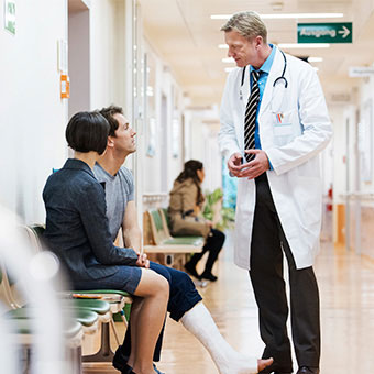A male patient with a broken leg discusses complications of a hematoma with his doctor.