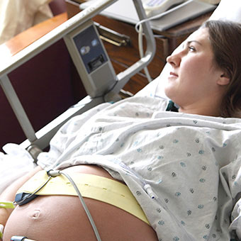 A pregnant woman in a hospital bed going into labor.