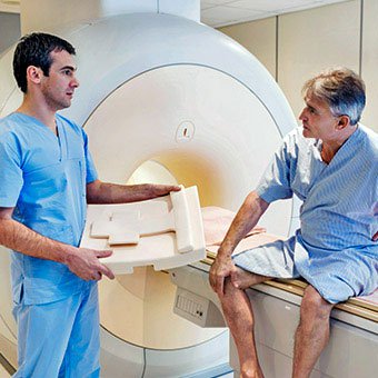 A technician prepares a patient for a CT scan.