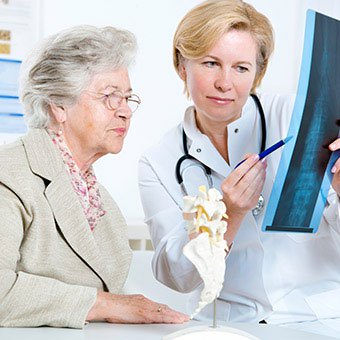 A doctor explains spinal X-ray results to a patient.