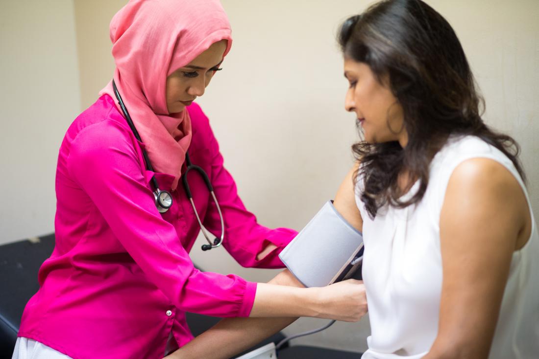doctor checking patients blood pressure