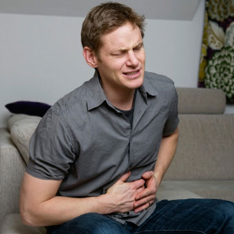 A man holds his stomach in pain.